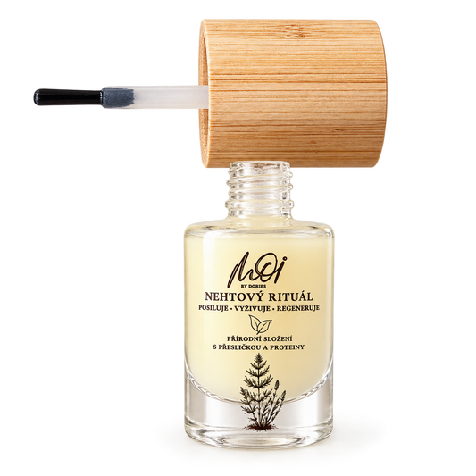 A clear glass bottle of MOI by Dories Nehtovy rituál serum with a light beige liquid, topped with a bamboo cap and shown with its applicator brush on a white background.